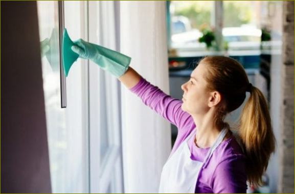 Naine puhastab aknaid
